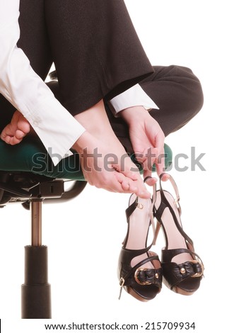Break from work. Leg pain of tired businesswoman. Young woman massaging her feet on chair isolated on white.