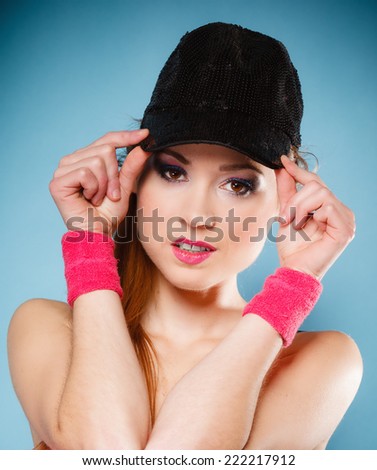 Happy people concept - sporty teen girl smiling in black baseball cap blue background