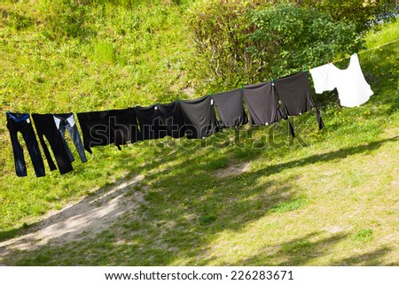 Housework. Clean wet laundry clothes hanging to dry on the line clothesline outdoor. Village.