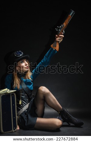 Criminal story bad girl steampunk retro woman with bag suitcase and gun studio shot grunge dark background