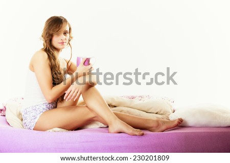 Relax, home, happiness and people concept. Young woman sleepy girl sitting relaxing on bed at morning with cup of tea coffee