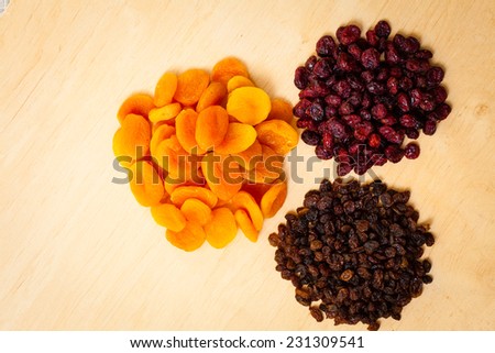 Healthy food organic nutrition. Dried dehydrated fruits raisins apricots and cranberries on wooden table