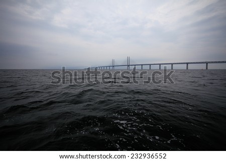 Oresundsbron. The Oresund bridge link between Denmark and Sweden, Europe, Baltic Sea. View from sailboat. Overcast stormy sky.