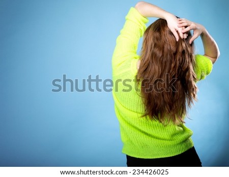 Beautiful female brown long healthy loose hair back view on blue background