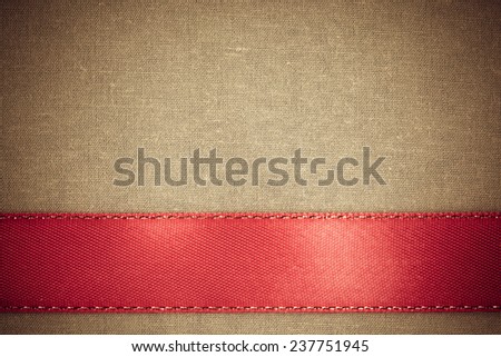 Empty banner on vintage background. Red ribbon on brown fabric cloth texture with copy space.