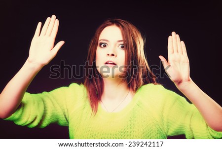 Scared. young woman teen girl making stop gesture sign with hands palms on black.