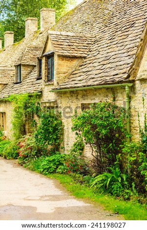 BIBURY, ENGLAND, UK - SEPTEMBER 21, 2014: Arlington Row traditional Cotswold stone cottages in Gloucestershire on September 21, 2014, England. Bibury it the most depicted village in the world.