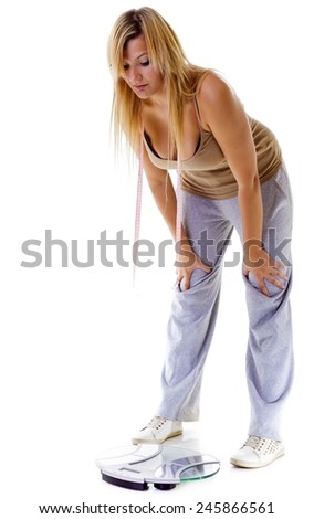 Health care overweight problem. Woman plus size large girl with scale unhappy very worried looking depressed with her weight control, studio shot isolated on white