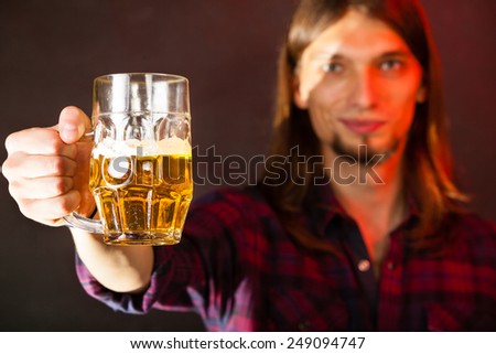 handsome young man guy holding a glass mug of beer