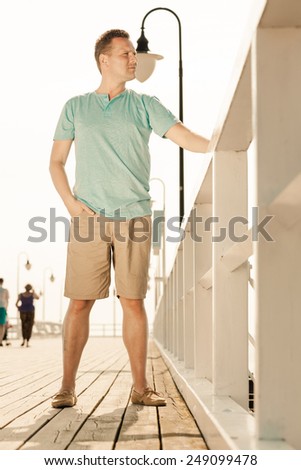 Happiness summer vacation and people concept. Fashion portrait of handsome man on pier