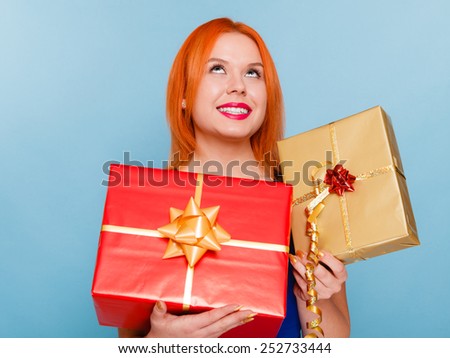 People celebrating holidays, love and happiness concept - happy joyful red hair girl with gift boxes studio shot on blue background