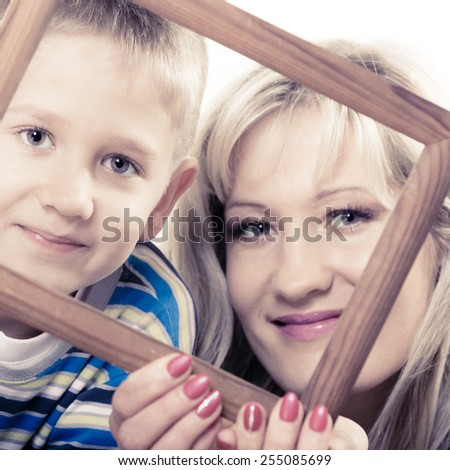 Happy family and love concept. Portrait of middle-aged mother with son little boy holding frame decorations