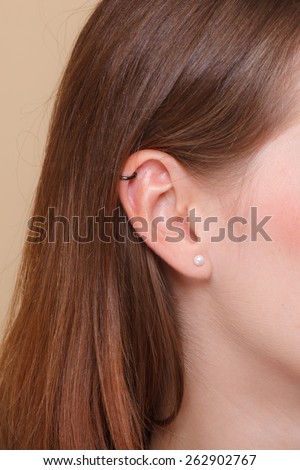 Closeup human female pierced ear with earrings