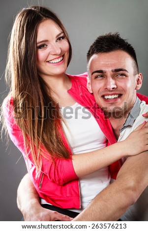 Love dating and people concept. Smiling young couple portrait on gray