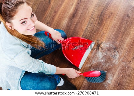 Cleanup housework concept. cleaning woman sweeping wooden floor with red small whisk broom and dustpan unusual high angle view