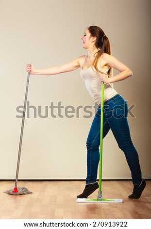 Cleanup housework concept. Funny cleaning lady young woman mopping floor, holding two mops new and old dancing