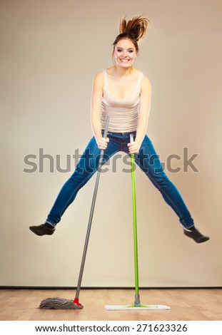 Cleanup housework concept. Funny cleaning lady young woman mopping floor, holding two mops new and old jumping