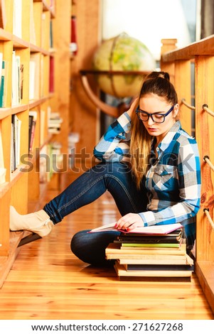 Education travel and geography concept. Young lovely woman female student in blue glasses in library pointing to globe