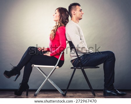 Bad relationship concept. Man and woman in disagreement. Young couple after quarrel sitting on chairs back to back