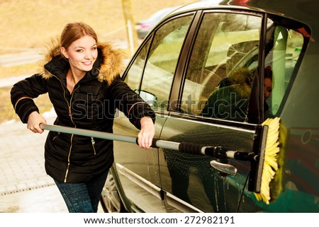 Auto wash. Young attractive blonde woman washing the dirty car on open air