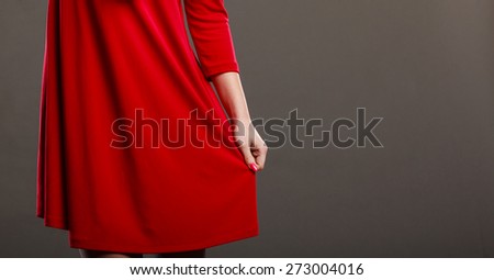 Woman part body. Dance posing girl in red dress on gray background in studio.