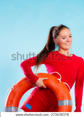 Accident prevention and water rescue. Young woman female smiling lifeguard on duty holding lifesaver equipment on blue