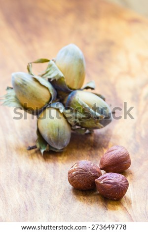 Healthy food full of fatty acids, organic nutrition. Hazelnuts  kernel and cluster filbert nuts in hard shell on rustic old wooden table.