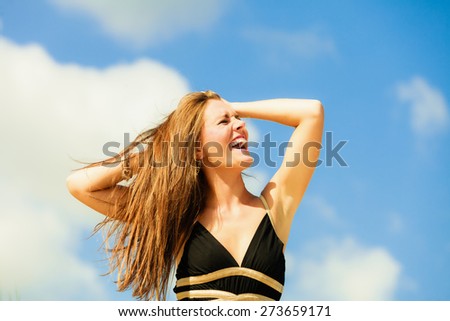 Very happy full emotions long hair woman in black on beach.