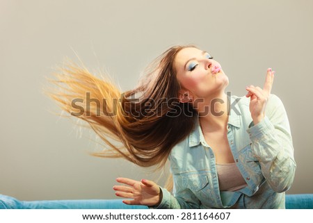 Young people happiness concept. Fashionable girl with long hair blowing