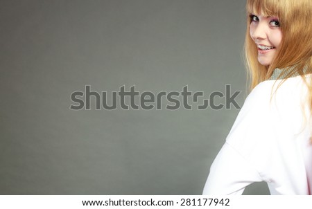 Face of young blonde woman with bangs gray background copy space text area