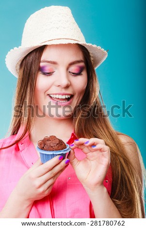 Sweet food sugar make us happy. Smiling woman summer clothing holds cake chocolate muffin in hand blue background