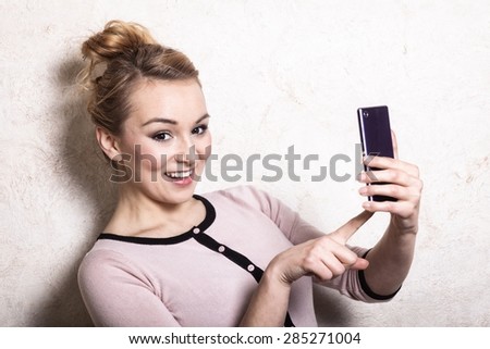 Portrait of businesswoman texting on the mobile phone. Woman reading sms on smartphone. Girl taking photo of herself.  Indoor.