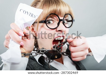 Business and stress concept. Furious businesswoman in glasses with chained hands holding contract grunge background unusual angle view
