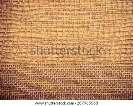 Jute bagging ribbon on brown mesh material, natural burlap ecology background