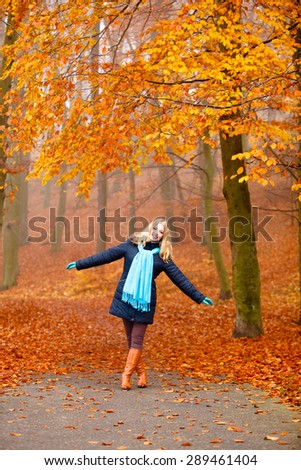 Fall lifestyle concept, harmony freedom. Beauty young woman fashion girl relaxing walking in autumn park, outdoor golden leaves background