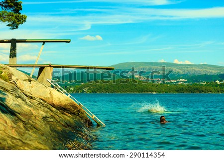 Summer vacation and dangerous sport. View of diving board. Springboard to dive at water. Fjord landscape