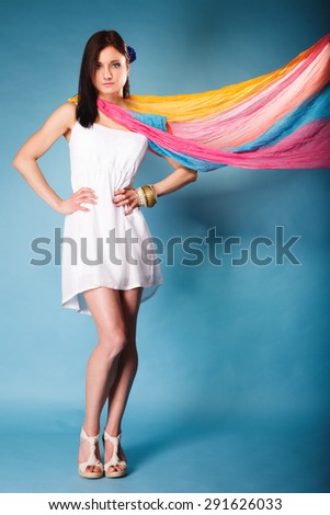 Summer fashion. Full length beauty young woman fashionable sensual girl with multicolored flying shawl on blue background