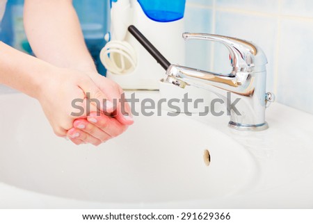 Hygiene. woman cleaning washing hands under flowing tap water in the bathroom