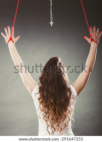 Tied woman forced to worship. Fake faith belief concept. Christian religion. Girl praying to god because of society pressure.