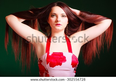 Hairdresser, hairstylist and haircare. Long haired beauty woman creating coiffure. Studio shot on green background.