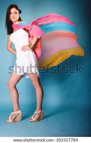 Summer fashion. Full length beauty young woman fashionable sensual girl with multicolored flying shawl on blue background