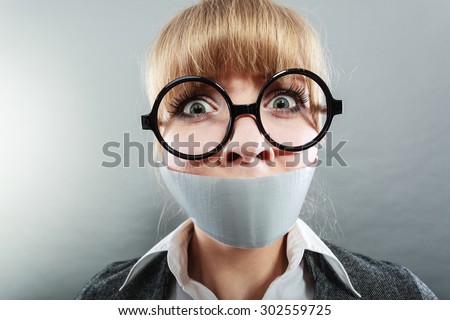 Scared woman with mouth taped shut. Afraid young girl with duct tape on lips. Censorship and freedom of speech concept.