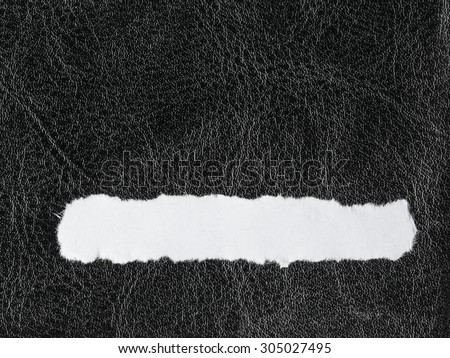 Piece scrap of white torn or ripped paper banner, blank copy space for text message on black leather background