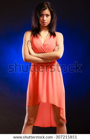 Party clothing evening fashion concept - Portrait attractive fashion woman, mixed race girl in orange elegant dress dark blue background