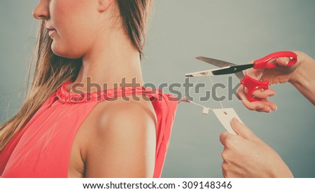 Woman girl removing cutting label board price tag off new dress cloth with scissors. Female after shopping. Instagram filter.