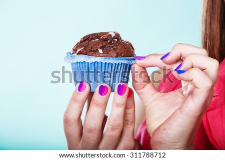 Delicious tasty sweet chocolate muffin in human hands. Confectionery food. Gluttony concept.
