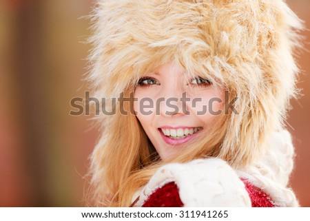 Portrait of pretty fashionable woman in fall forest park. Gorgeous young girl in fur winter hat. Autumn fashion.