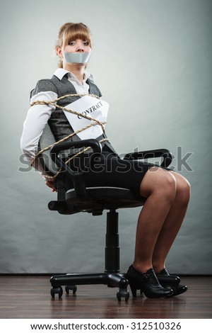 Afraid businesswoman bound by contract terms and conditions with mouth taped shut. Scared woman tied to chair become slave. Business and law concept.