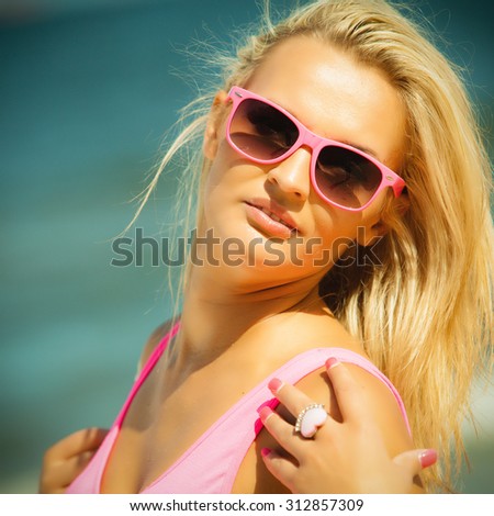Holidays, vacation and summer fashion concept. closeup attractive blonde girl in pink sunglasses on beach outdoor