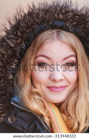 Portrait of pretty smiling fashionable woman in fall forest park. Happy gorgeous blonde young girl in jacket with hood. Autumn winter fashion.